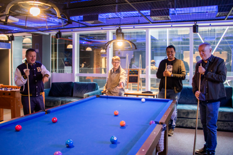 Grupo de homens jogando bilhar no escritório